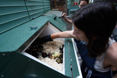 Lydia Baird mixes material into muslin scraps in preparation for the composting process.