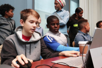 boys sitting in front of a computer screen