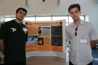 Two men in front of an academic poster